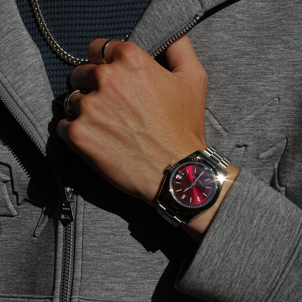 Elusivy watch on wrist with chain and chrome red dial